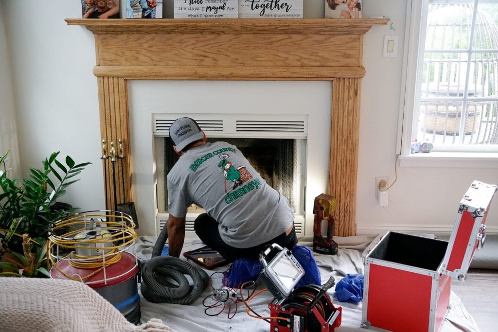 Original image of Mercer County Chimney Services tech checking a chimney.