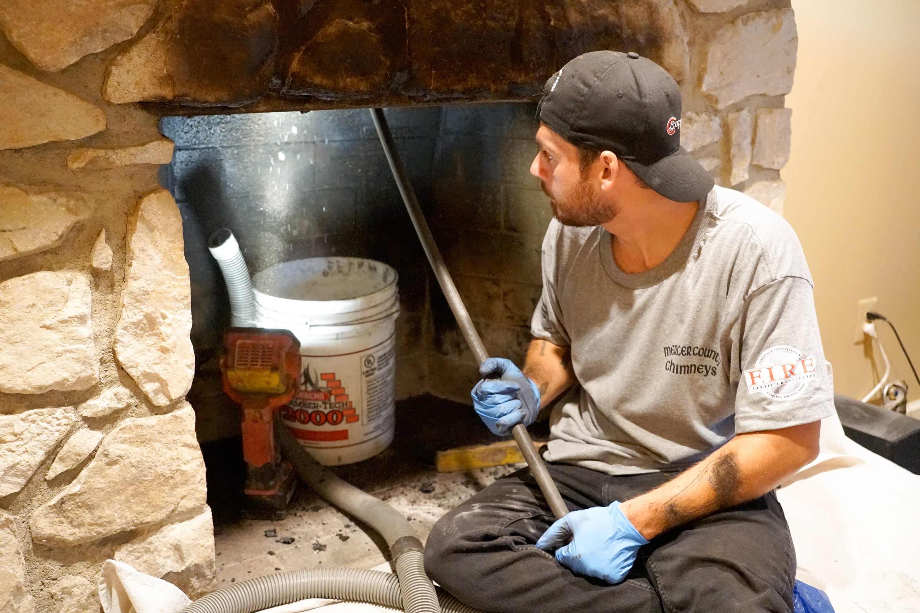 Original image of Mercer County Chimney Services tech cleaning chimney.